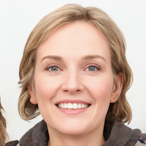 Joyful white young-adult female with medium  brown hair and blue eyes