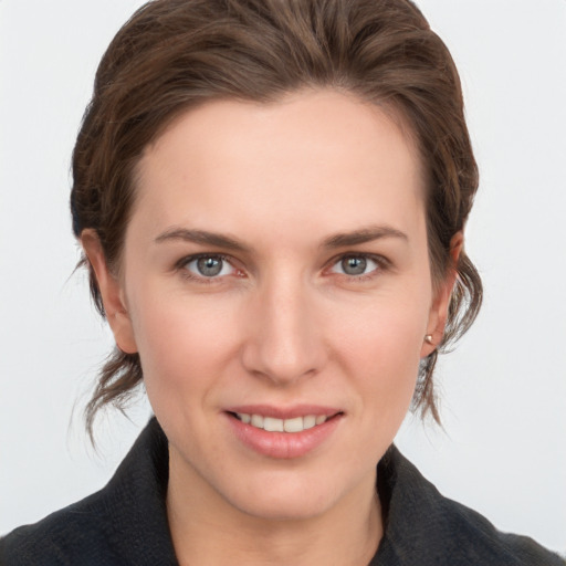 Joyful white young-adult female with medium  brown hair and grey eyes