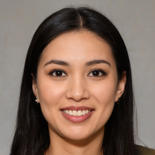 Joyful latino young-adult female with long  brown hair and brown eyes