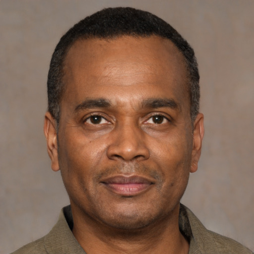 Joyful black adult male with short  brown hair and brown eyes