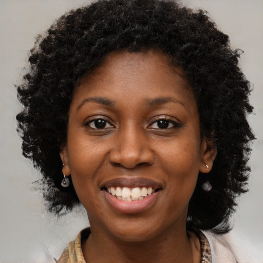 Joyful black young-adult female with medium  brown hair and brown eyes