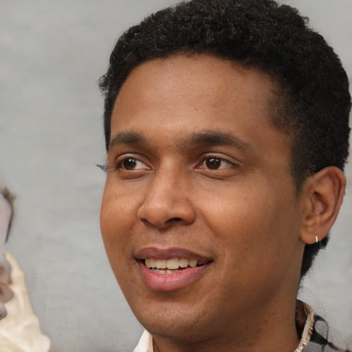Joyful black young-adult male with short  brown hair and brown eyes