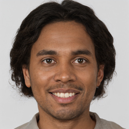 Joyful black young-adult male with short  brown hair and brown eyes