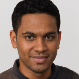 Joyful latino young-adult male with short  brown hair and brown eyes