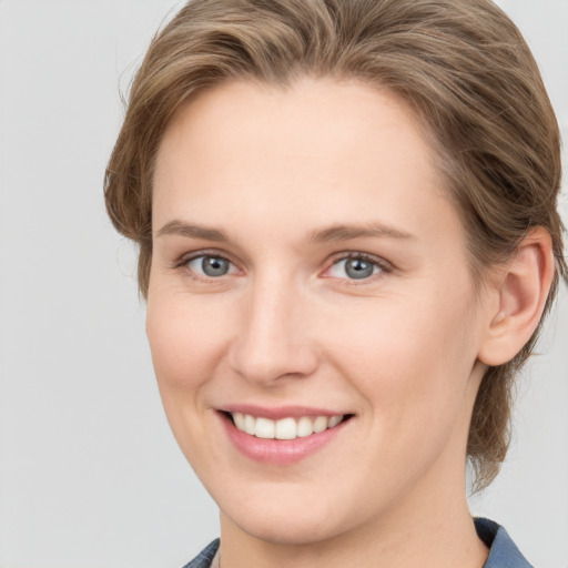 Joyful white young-adult female with medium  brown hair and blue eyes