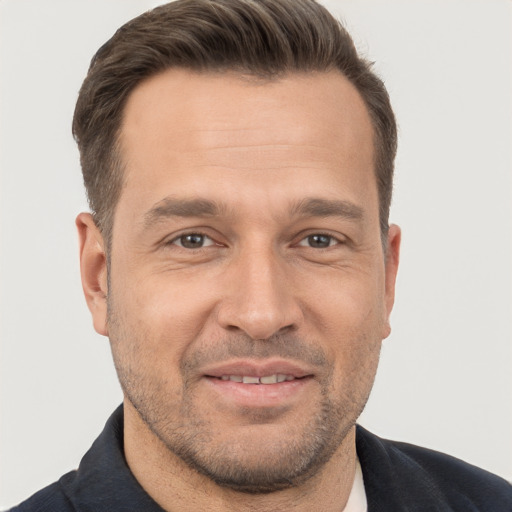 Joyful white adult male with short  brown hair and brown eyes