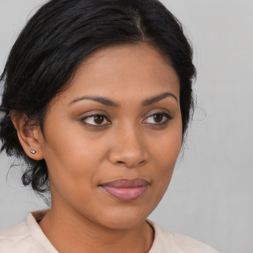 Joyful latino young-adult female with medium  brown hair and brown eyes