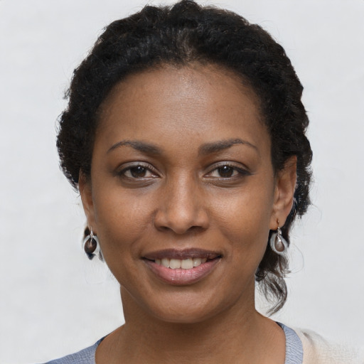 Joyful black young-adult female with short  brown hair and brown eyes