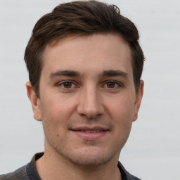 Joyful white young-adult male with short  brown hair and grey eyes