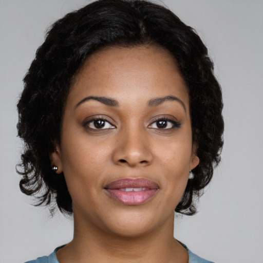Joyful black young-adult female with short  black hair and brown eyes