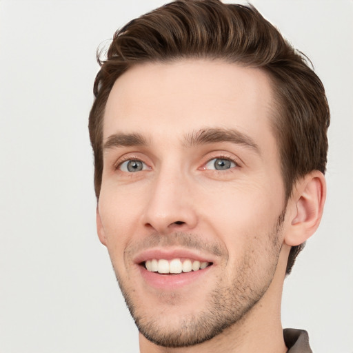 Joyful white young-adult male with short  brown hair and grey eyes