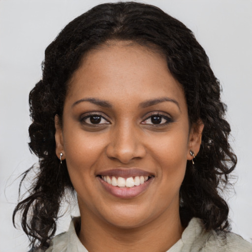 Joyful black young-adult female with long  brown hair and brown eyes