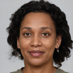 Joyful black adult female with medium  brown hair and brown eyes