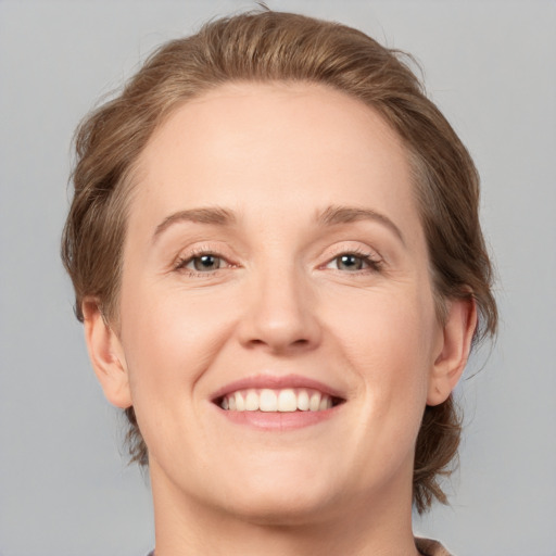 Joyful white adult female with medium  brown hair and grey eyes