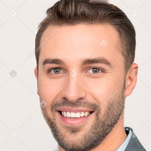 Joyful white young-adult male with short  brown hair and brown eyes