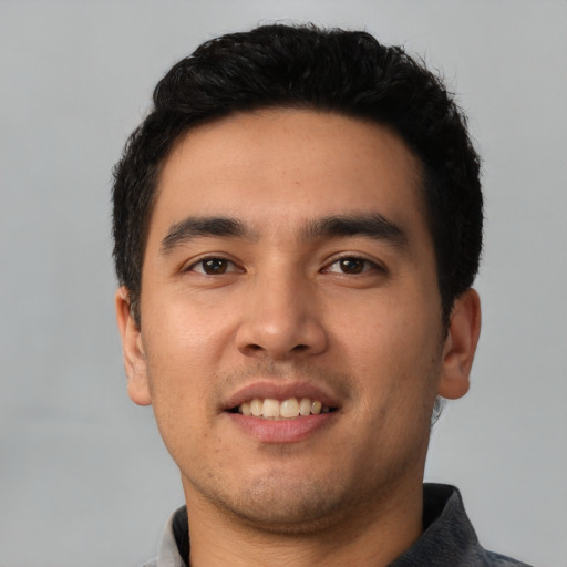 Joyful latino young-adult male with short  black hair and brown eyes
