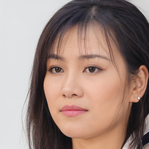 Joyful asian young-adult female with long  brown hair and brown eyes