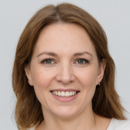 Joyful white adult female with medium  brown hair and grey eyes