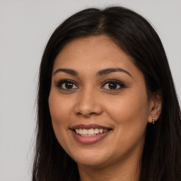 Joyful latino young-adult female with long  brown hair and brown eyes