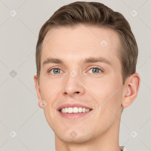 Joyful white young-adult male with short  brown hair and grey eyes