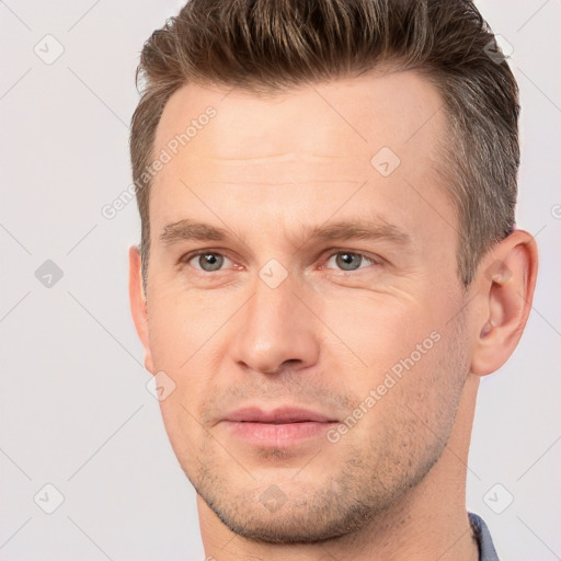 Joyful white young-adult male with short  brown hair and brown eyes