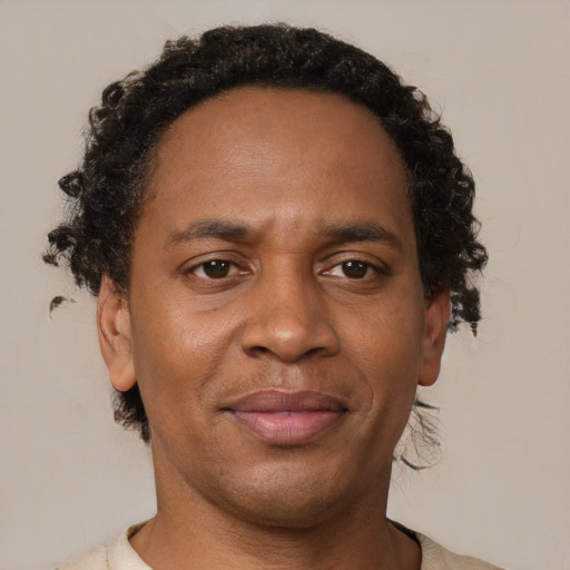 Joyful black adult male with short  brown hair and brown eyes