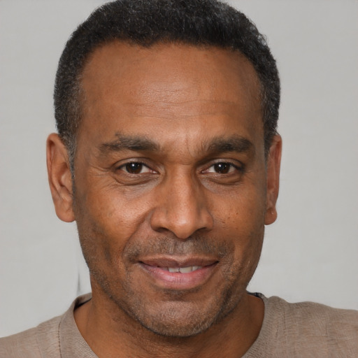 Joyful black adult male with short  brown hair and brown eyes