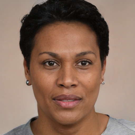 Joyful black young-adult female with short  black hair and brown eyes
