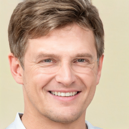 Joyful white adult male with short  brown hair and grey eyes