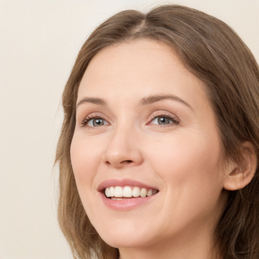 Joyful white young-adult female with long  brown hair and green eyes