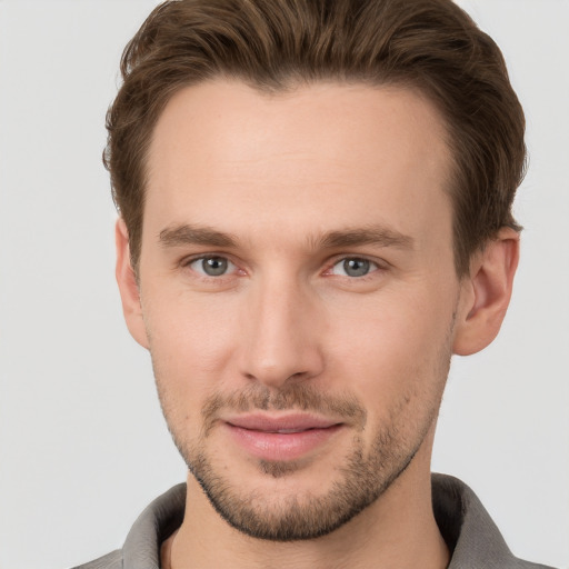 Joyful white young-adult male with short  brown hair and grey eyes