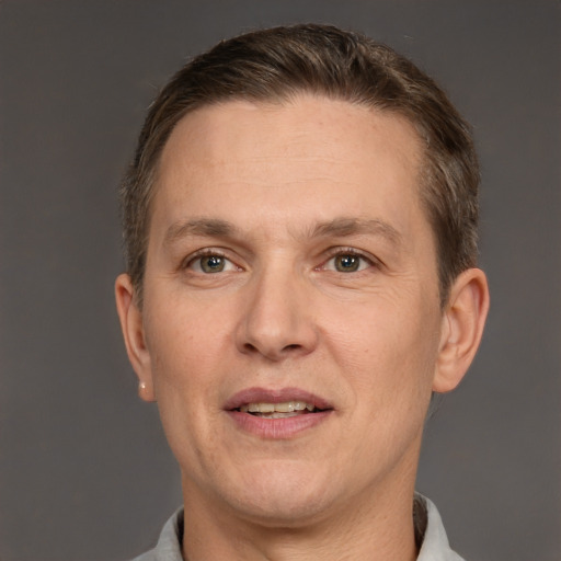 Joyful white adult male with short  brown hair and grey eyes