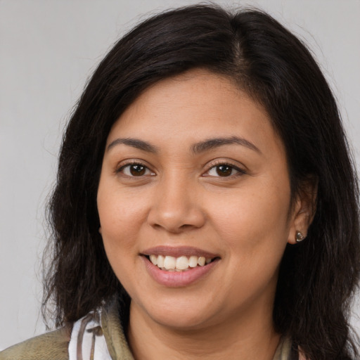 Joyful latino young-adult female with long  brown hair and brown eyes
