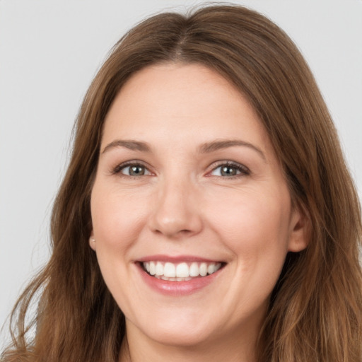 Joyful white young-adult female with long  brown hair and brown eyes