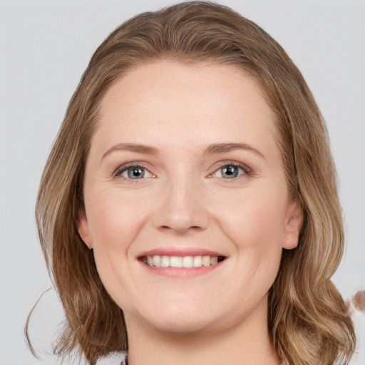 Joyful white young-adult female with long  brown hair and blue eyes