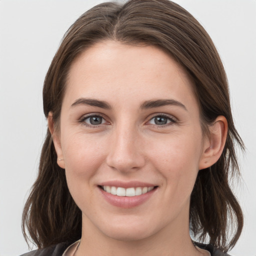 Joyful white young-adult female with medium  brown hair and grey eyes