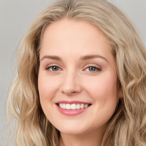 Joyful white young-adult female with long  brown hair and blue eyes