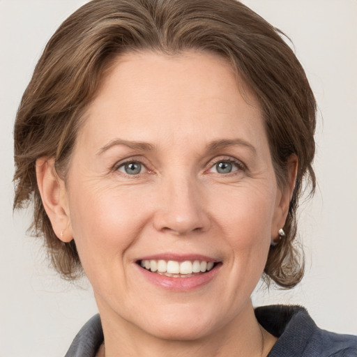 Joyful white adult female with medium  brown hair and grey eyes