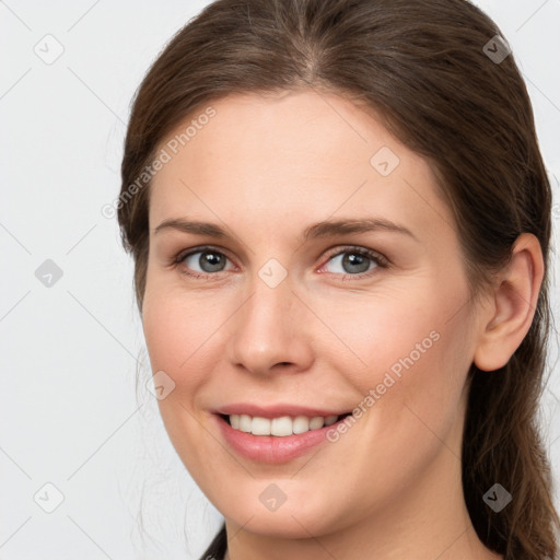 Joyful white young-adult female with long  brown hair and brown eyes