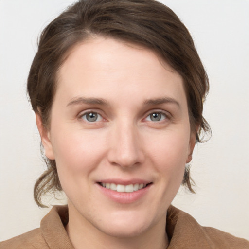 Joyful white young-adult female with medium  brown hair and grey eyes