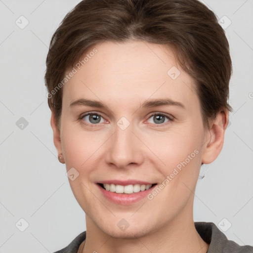 Joyful white young-adult female with short  brown hair and grey eyes