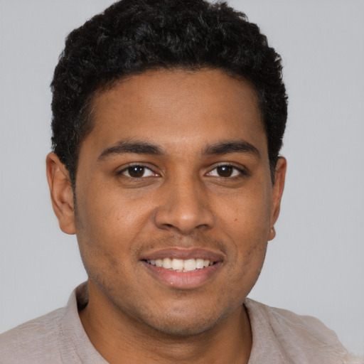 Joyful black young-adult male with short  brown hair and brown eyes