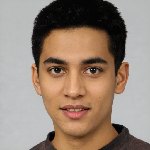 Joyful latino young-adult male with short  black hair and brown eyes