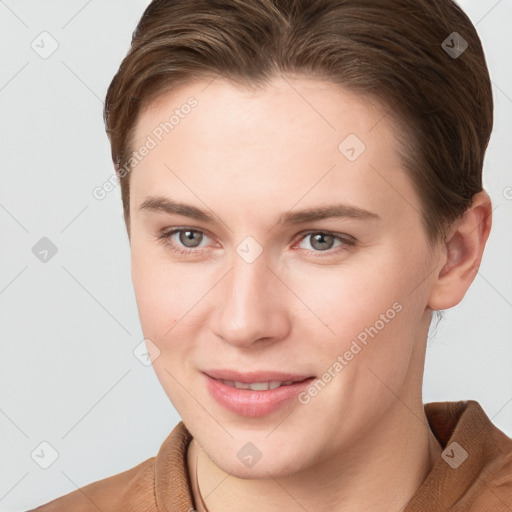 Joyful white young-adult female with short  brown hair and grey eyes