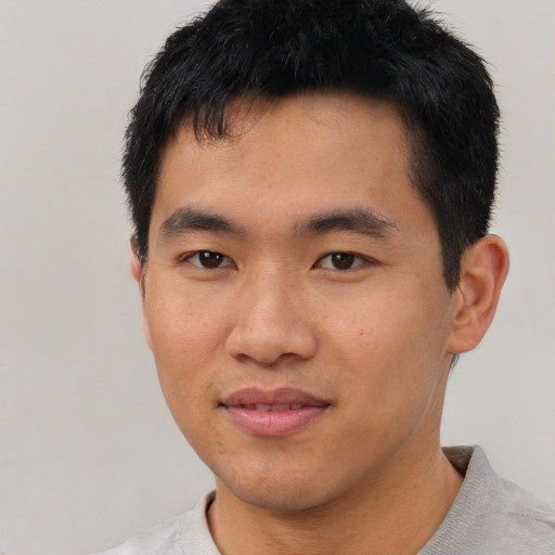 Joyful asian young-adult male with short  black hair and brown eyes