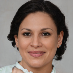 Joyful latino adult female with medium  brown hair and brown eyes