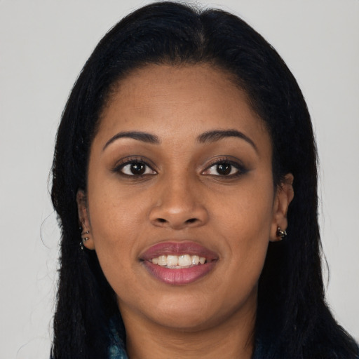 Joyful black young-adult female with long  black hair and brown eyes