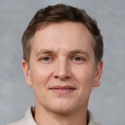 Joyful white adult male with short  brown hair and grey eyes