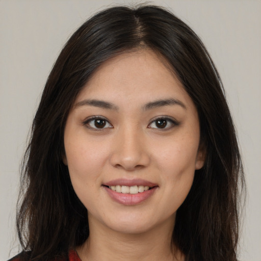 Joyful latino young-adult female with long  brown hair and brown eyes