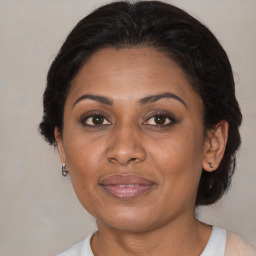 Joyful black adult female with medium  brown hair and brown eyes